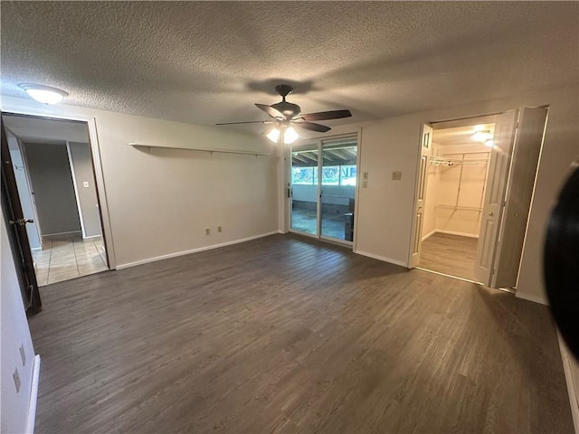 unfurnished bedroom featuring ceiling fan, dark hardwood / wood-style floors, access to exterior, a textured ceiling, and a closet