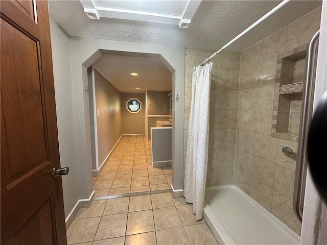 bathroom featuring tile patterned flooring, a shower with curtain, and a textured ceiling