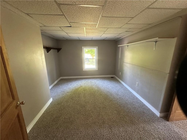 carpeted empty room with a drop ceiling