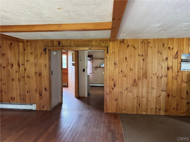 unfurnished room with a baseboard heating unit, wooden walls, and beam ceiling