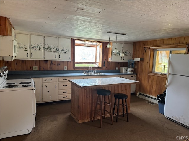 kitchen featuring a center island, white appliances, white cabinets, decorative light fixtures, and sink