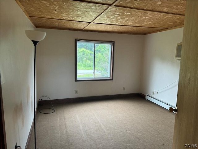 carpeted spare room with baseboards and a baseboard heating unit