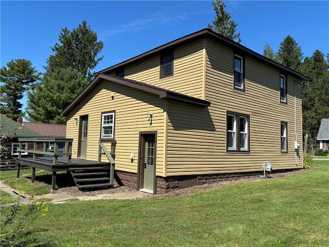 rear view of property with a deck and a lawn