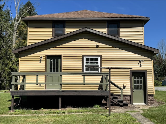 back of house featuring a deck and a lawn