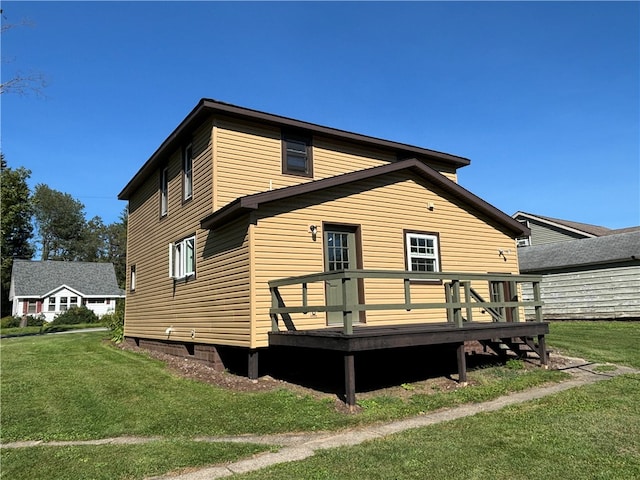 back of house with a wooden deck and a lawn