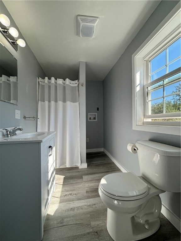 bathroom featuring wood-type flooring, vanity, and toilet