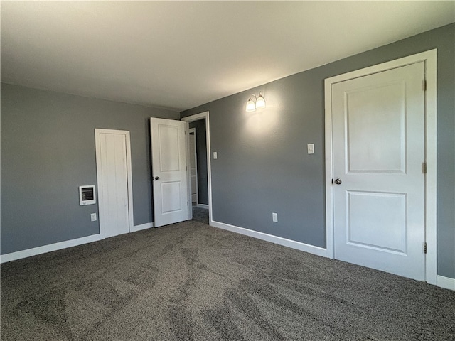 unfurnished bedroom featuring dark carpet