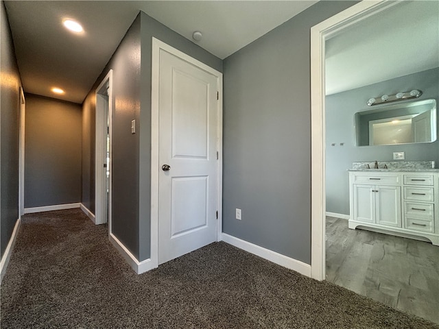 hallway featuring dark carpet