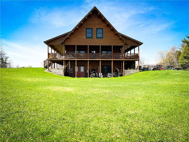 rear view of house featuring a lawn and a deck