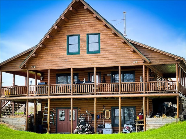 rear view of property featuring a balcony and a wooden deck