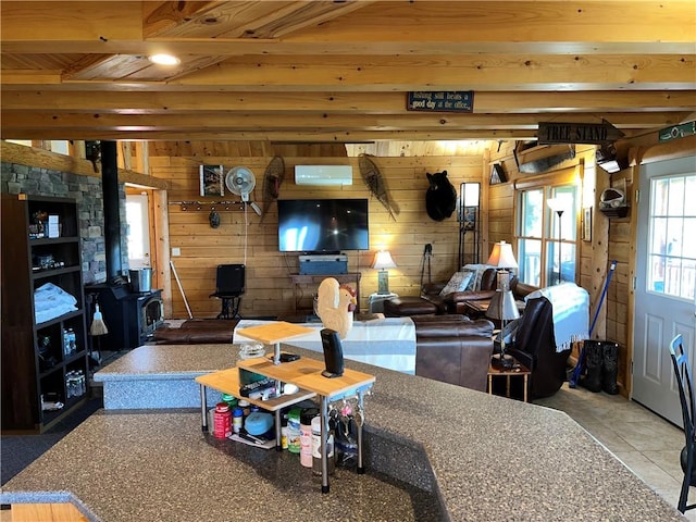 living room featuring a wall mounted air conditioner, wood walls, a wood stove, beam ceiling, and wood ceiling