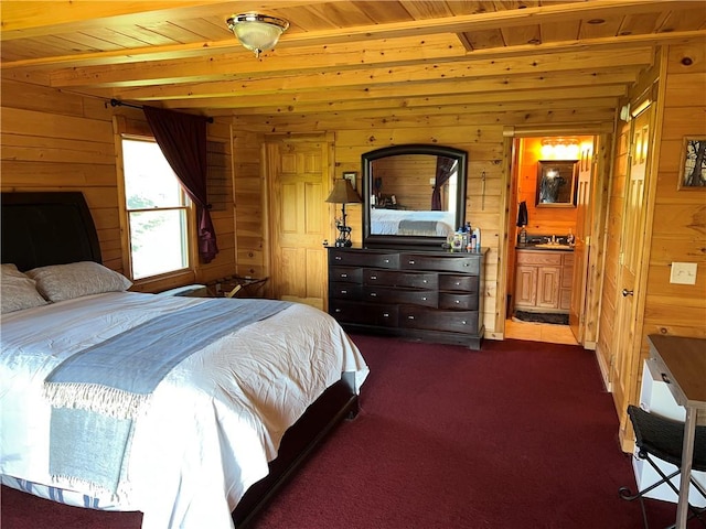 bedroom with beamed ceiling, wooden ceiling, wooden walls, and ensuite bath