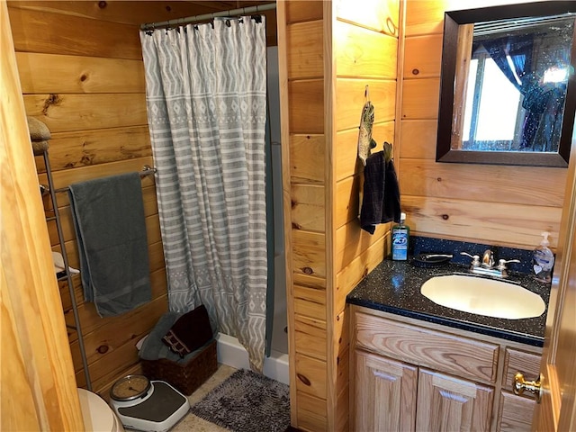 bathroom featuring a shower with curtain, vanity, toilet, and wood walls