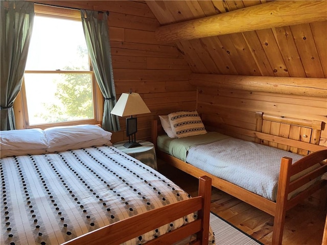 bedroom featuring hardwood / wood-style floors, wood walls, lofted ceiling, and multiple windows