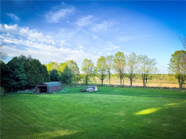 view of yard with a rural view and an outdoor structure