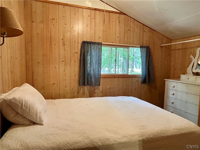 bedroom featuring wooden walls and lofted ceiling