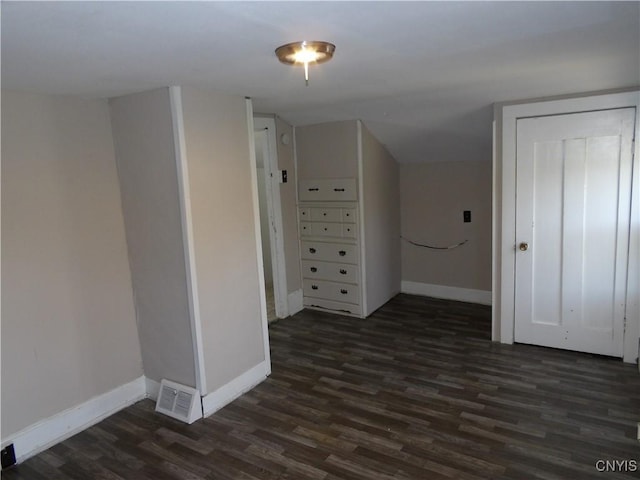 interior space featuring baseboards, dark wood-style floors, visible vents, and lofted ceiling