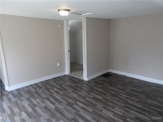 unfurnished room with baseboards and dark wood finished floors