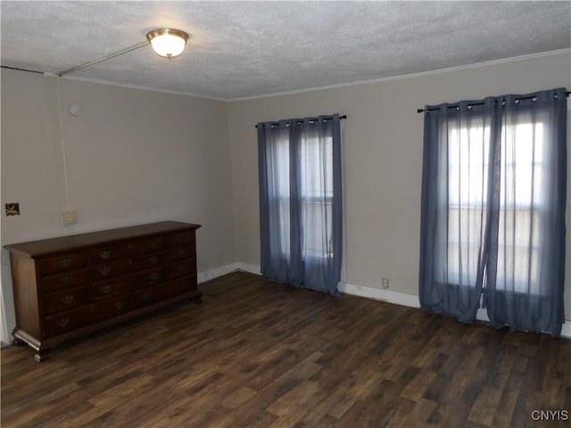 unfurnished room featuring dark wood-style flooring, ornamental molding, baseboards, and a textured ceiling