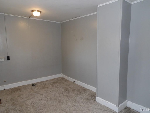empty room with baseboards, ornamental molding, and carpet