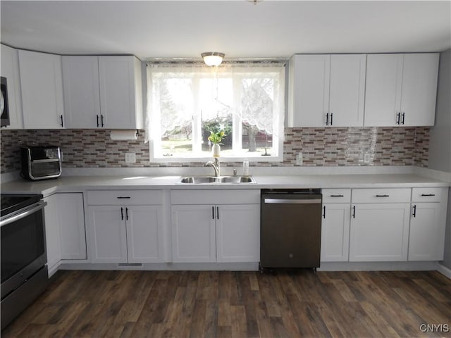 kitchen with dark wood finished floors, a sink, white cabinetry, and stainless steel appliances