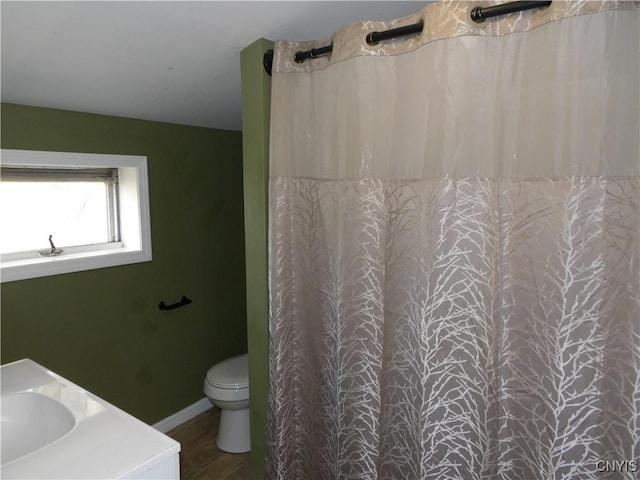 full bathroom with a sink, toilet, a shower with shower curtain, and baseboards