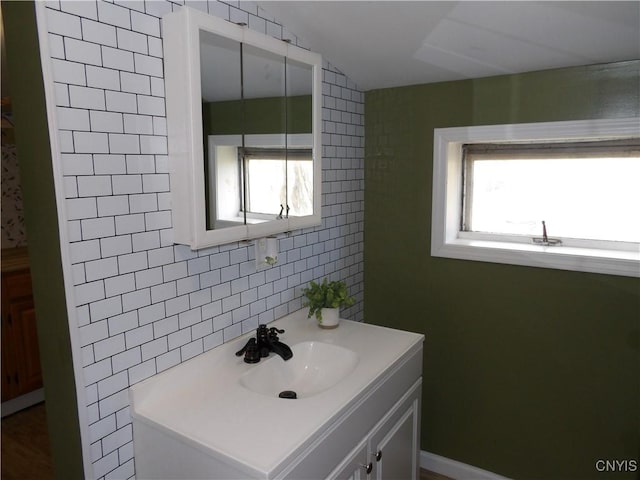 bathroom with tile walls, vanity, backsplash, and a wealth of natural light