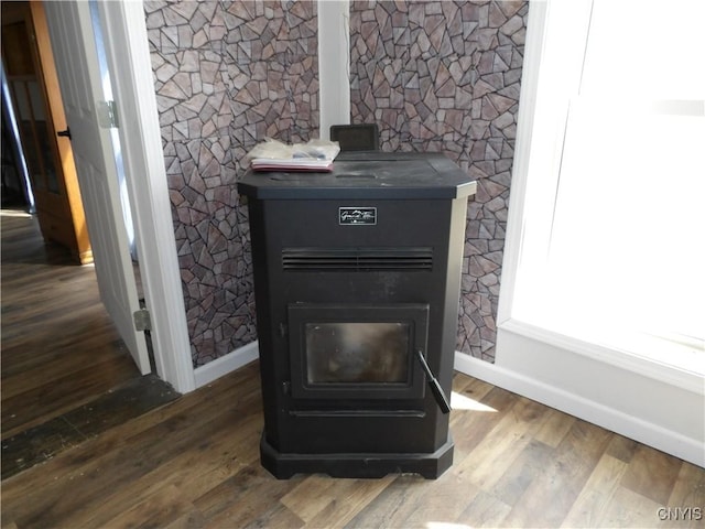 details with a wood stove, wood finished floors, and baseboards