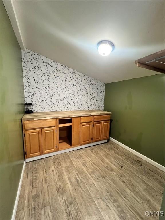 interior space with baseboards and light wood finished floors