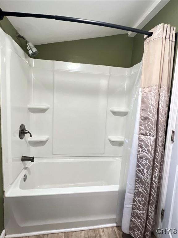 bathroom with shower / tub combo and wood finished floors