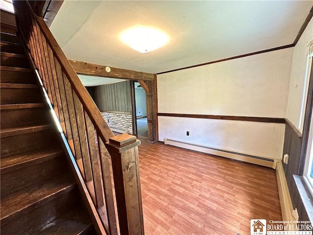 stairway with hardwood / wood-style flooring, crown molding, and a baseboard heating unit