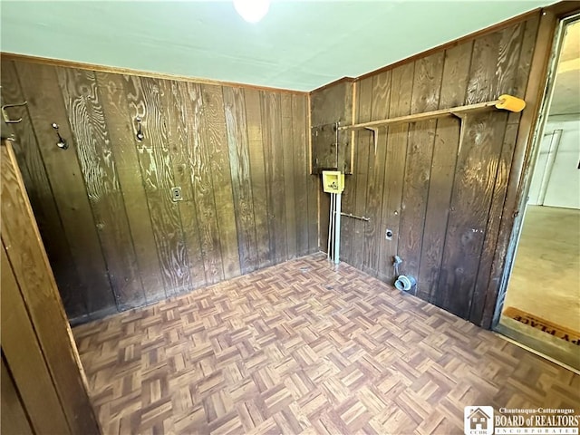 spare room featuring wooden walls and parquet floors