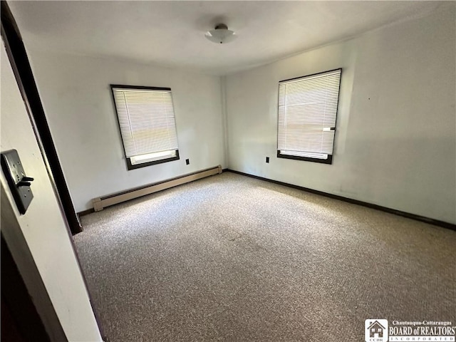 empty room featuring carpet floors and a baseboard heating unit