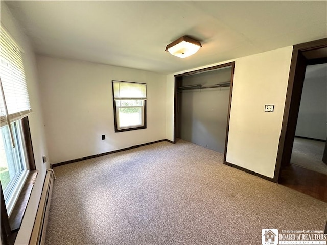 unfurnished bedroom with a closet, carpet floors, and a baseboard radiator