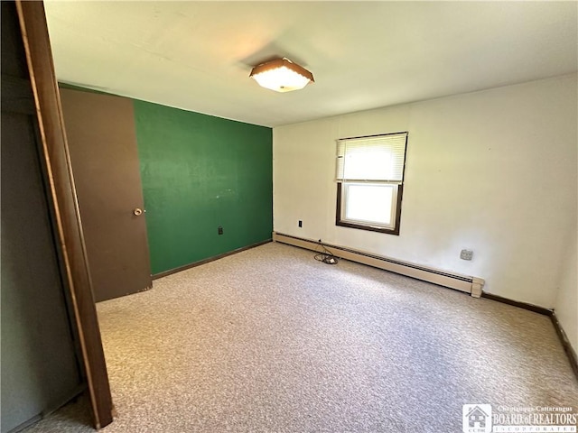 unfurnished room featuring baseboard heating and light carpet