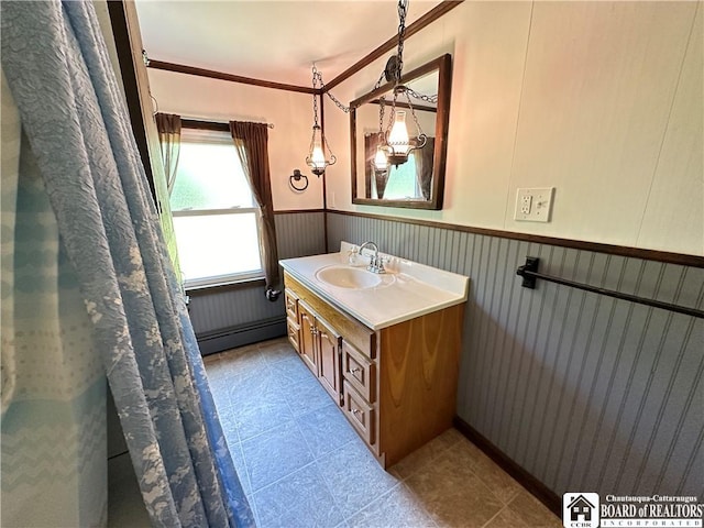 bathroom with baseboard heating, crown molding, tile patterned flooring, and vanity