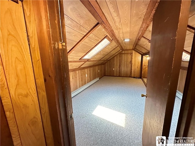 additional living space with lofted ceiling with skylight, wooden walls, a baseboard radiator, and wooden ceiling