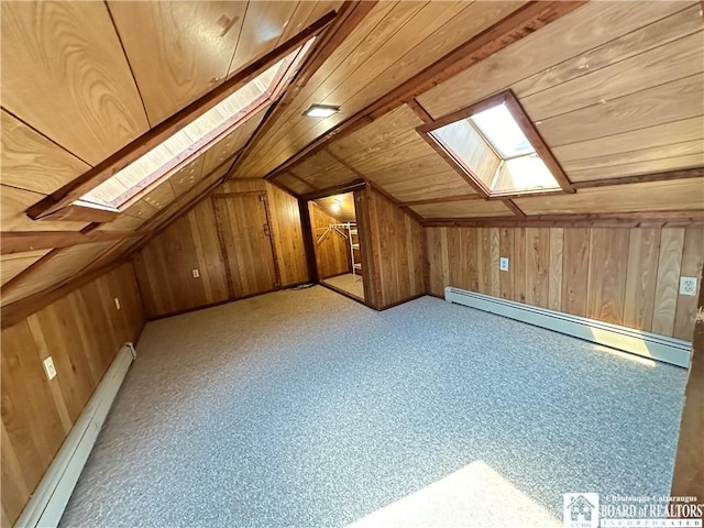 bonus room featuring wood walls, vaulted ceiling with skylight, and a baseboard radiator