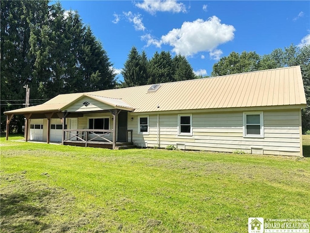 rear view of property featuring covered porch and a yard