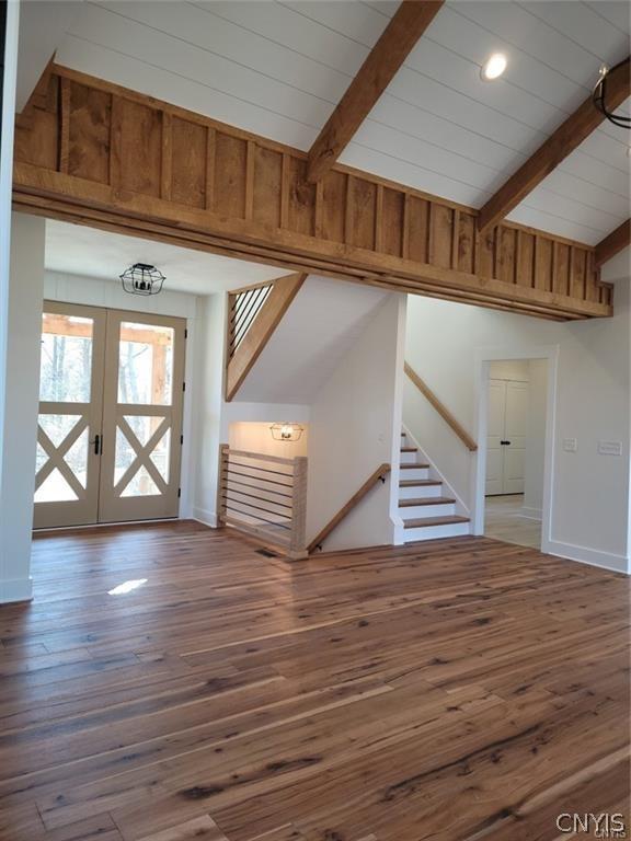 interior space featuring dark hardwood / wood-style flooring, french doors, a notable chandelier, high vaulted ceiling, and beam ceiling