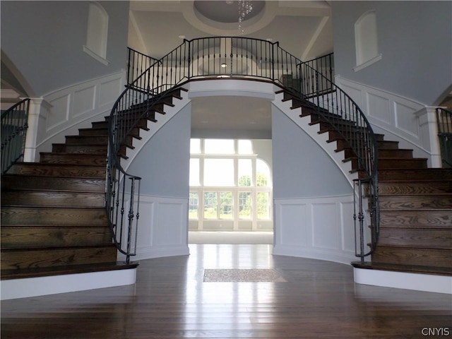 staircase featuring a high ceiling and wood-type flooring