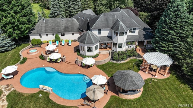 pool with a jacuzzi, a deck, outdoor dining area, a yard, and a patio area