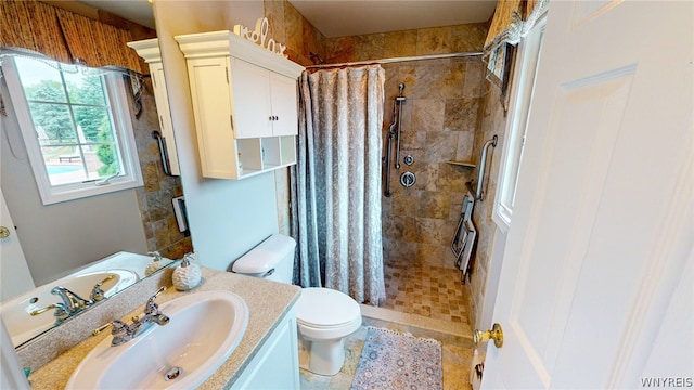 full bath with toilet, tiled shower, and vanity