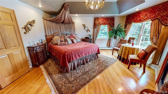 bedroom featuring light wood-type flooring, baseboard heating, a notable chandelier, and recessed lighting