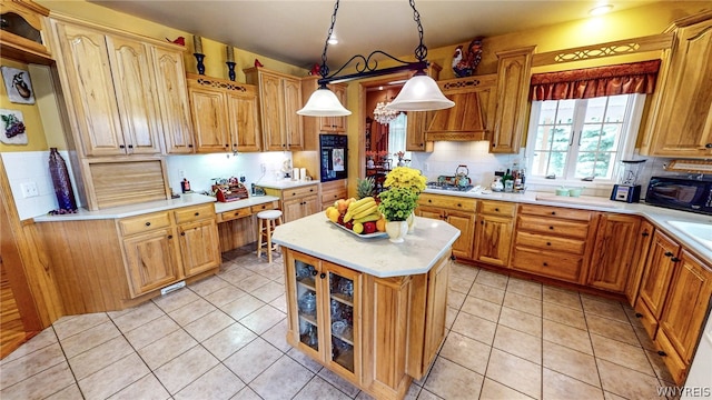 kitchen with light tile patterned floors, custom range hood, light countertops, black appliances, and backsplash