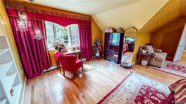 bedroom with an inviting chandelier, baseboard heating, vaulted ceiling, and hardwood / wood-style flooring