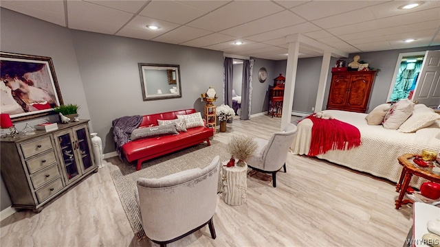 bedroom with recessed lighting, a drop ceiling, baseboards, and wood finished floors