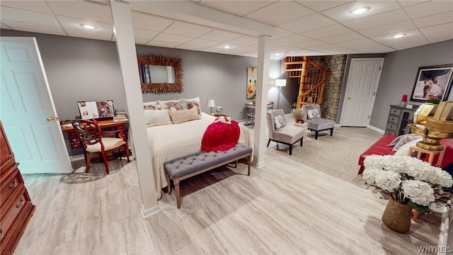 bedroom with a paneled ceiling, baseboards, wood finished floors, and recessed lighting