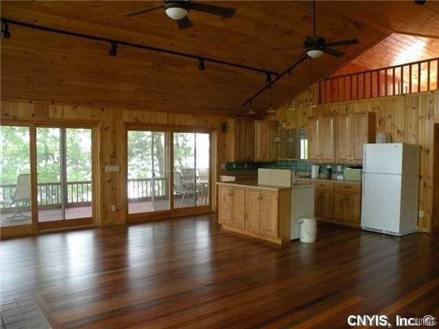 kitchen featuring hardwood / wood-style floors, white fridge, ceiling fan, and rail lighting