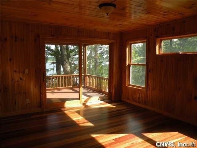 interior space featuring wooden ceiling, dark wood-type flooring, and wood walls